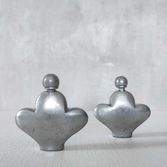 A pair of small vintage cast pewter perfume bottles