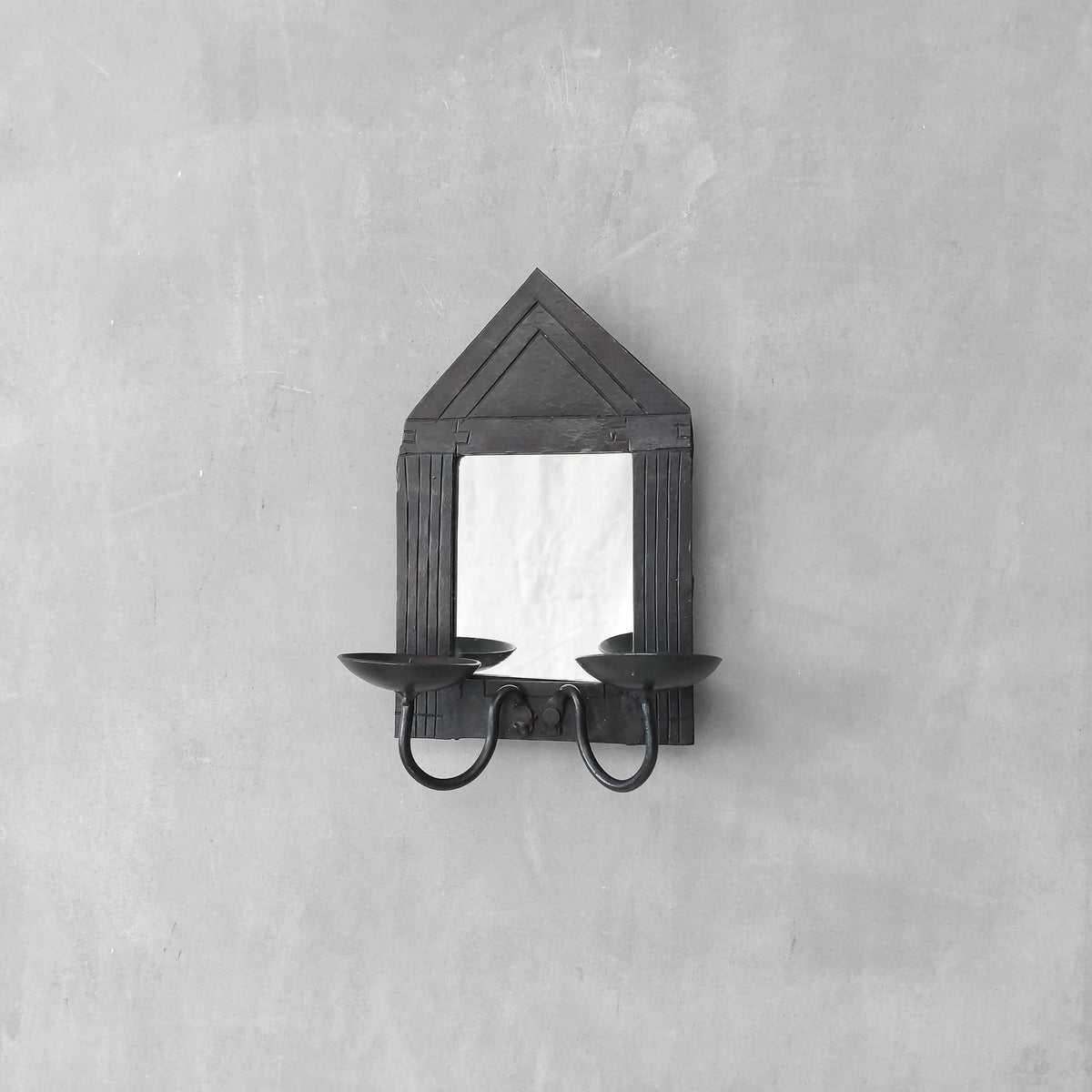 A small vintage architectural pedimented steel framed mirror candle sconce