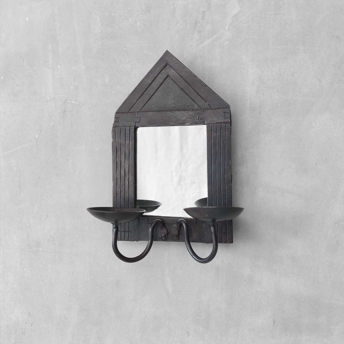 A small vintage architectural pedimented steel framed mirror candle sconce