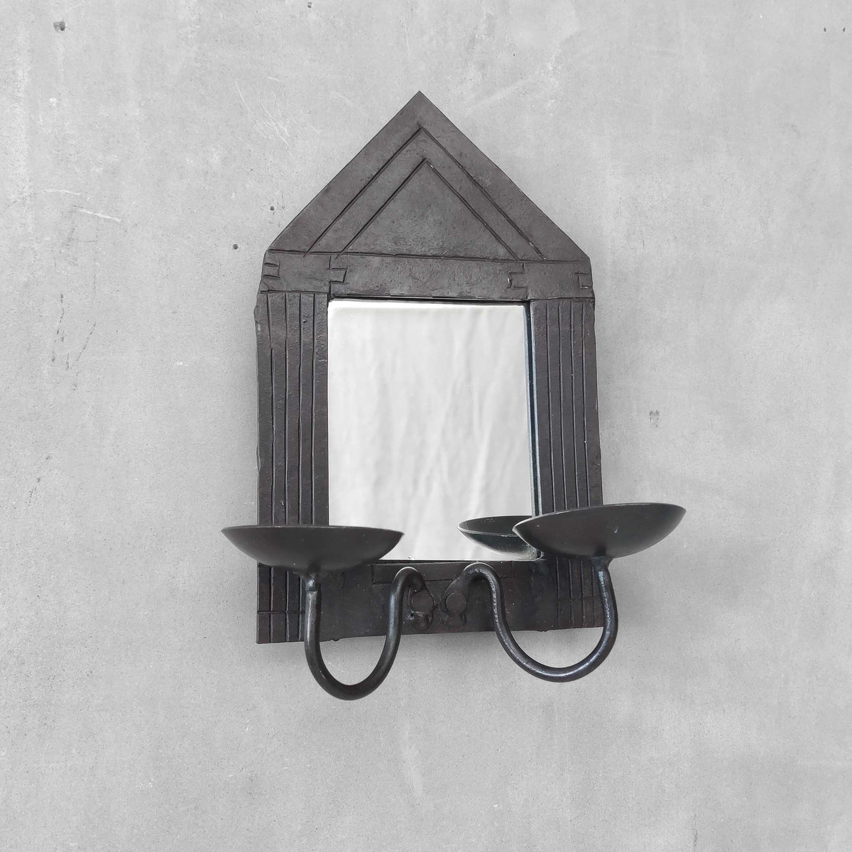 A small vintage architectural pedimented steel framed mirror candle sconce