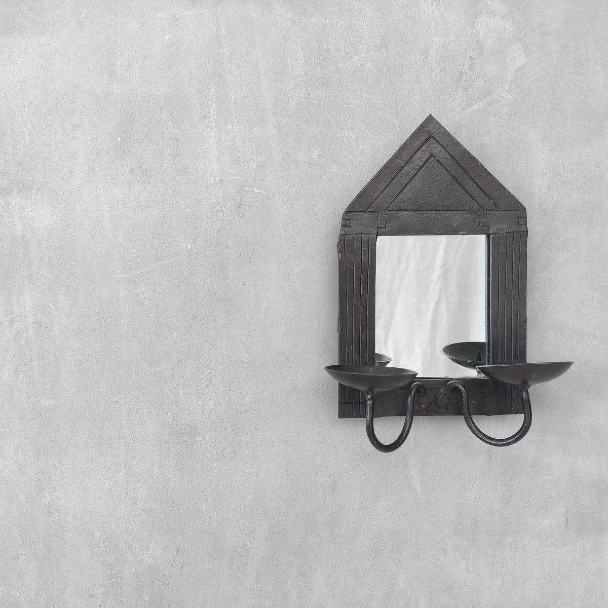 A small vintage architectural pedimented steel framed mirror candle sconce