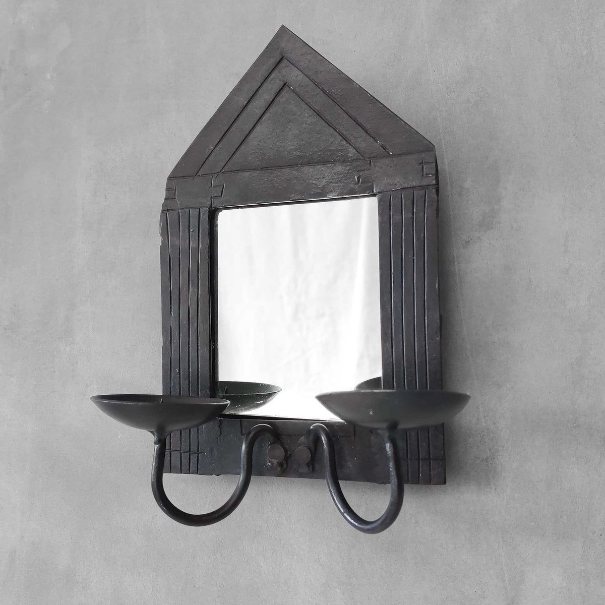 A small vintage architectural pedimented steel framed mirror candle sconce