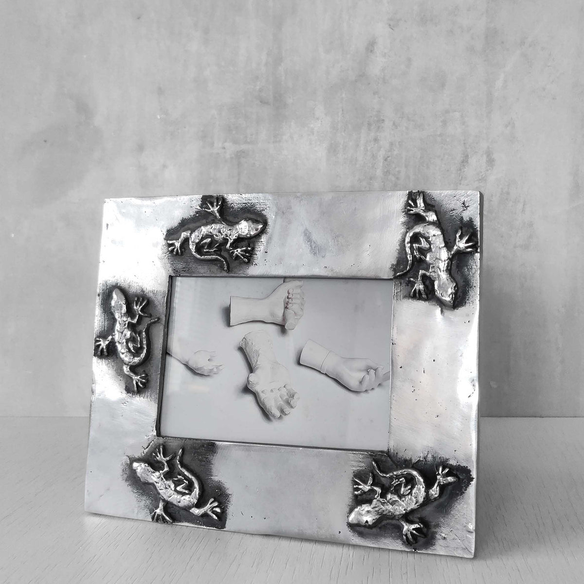 A vintage hand sand cast aluminium photo frame with gecko motifs