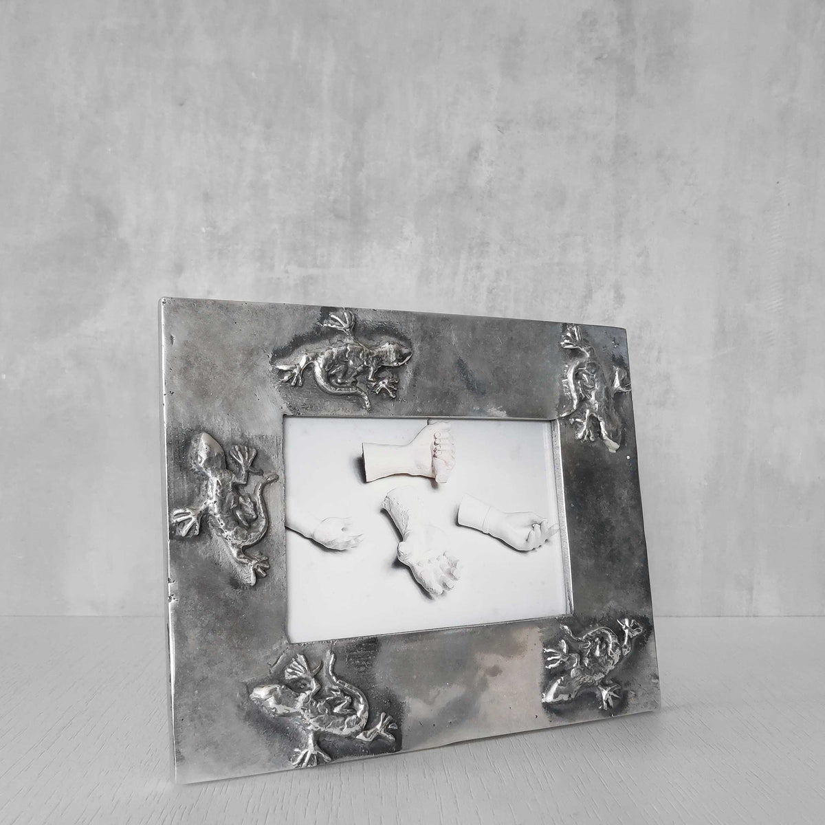 A vintage hand sand cast aluminium photo frame with gecko motifs