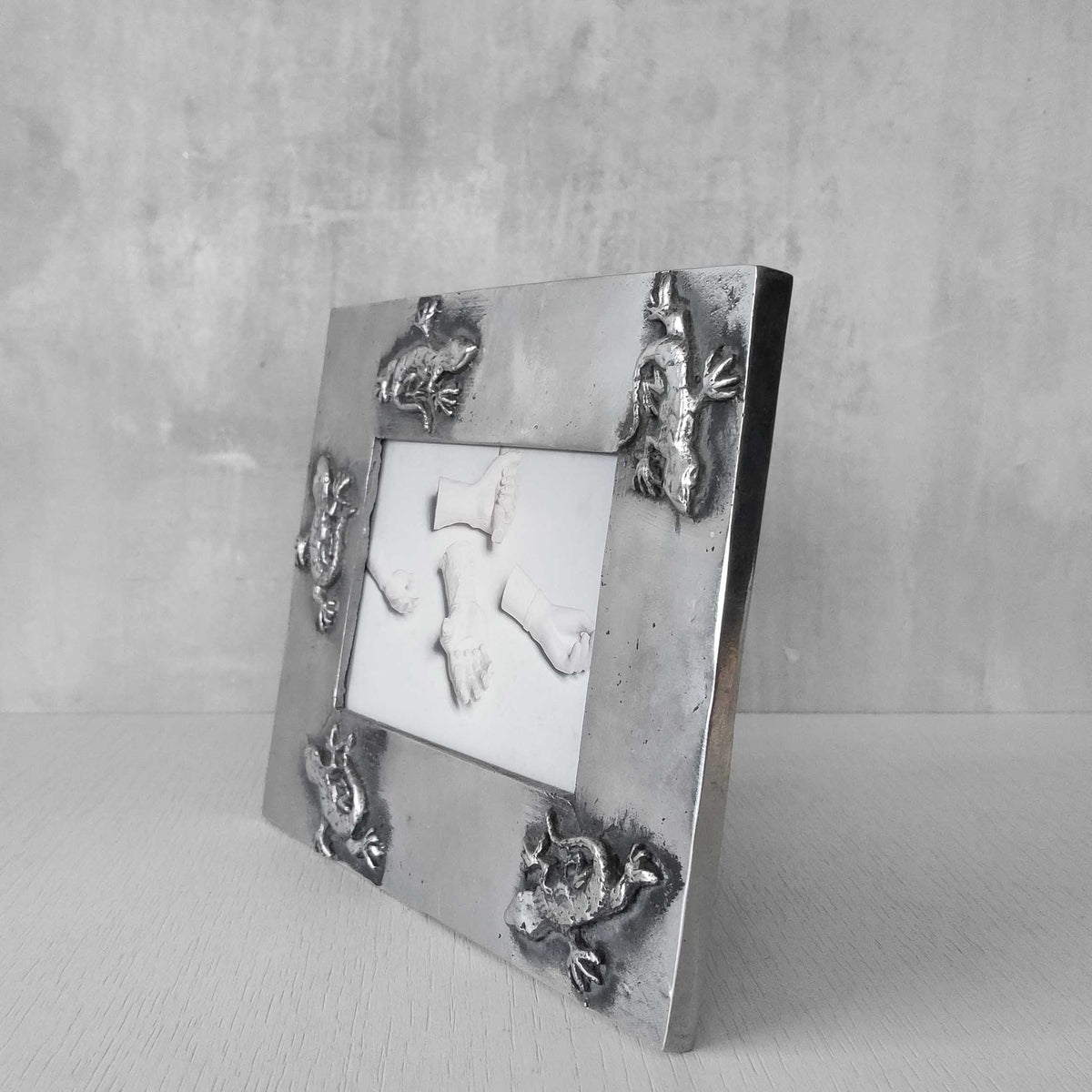 A vintage hand sand cast aluminium photo frame with gecko motifs