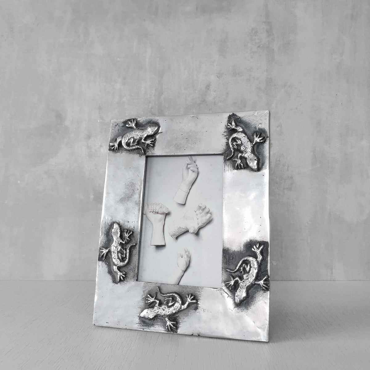 A vintage hand sand cast aluminium photo frame with gecko motifs