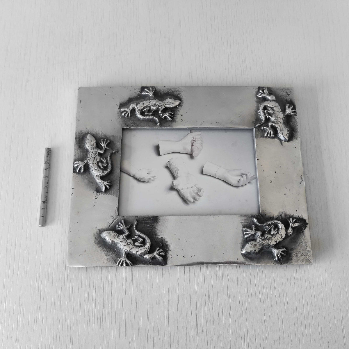 A vintage hand sand cast aluminium photo frame with gecko motifs