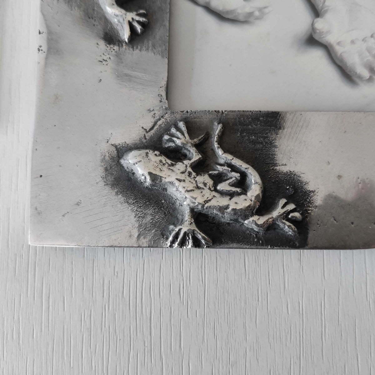 A vintage hand sand cast aluminium photo frame with gecko motifs