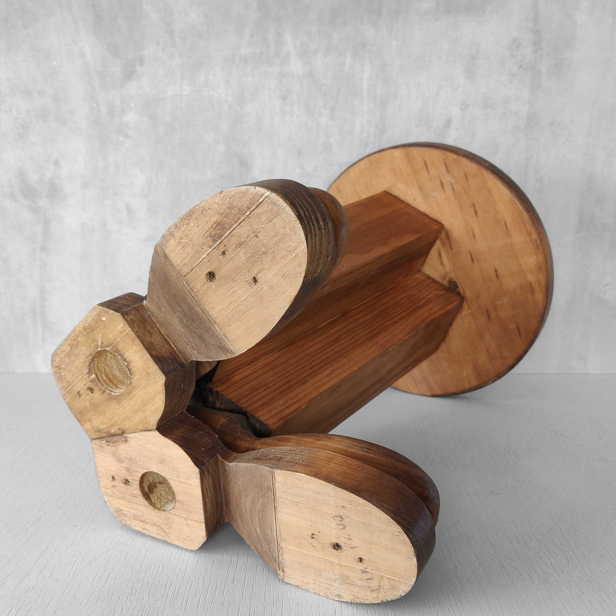 A 1980s postmodern pop art revival pine stool or plinth with booted feet