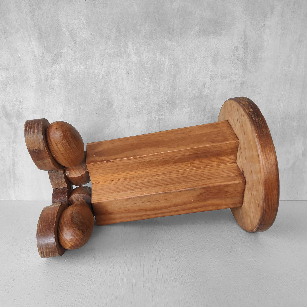 A 1980s postmodern pop art revival pine stool or plinth with booted feet