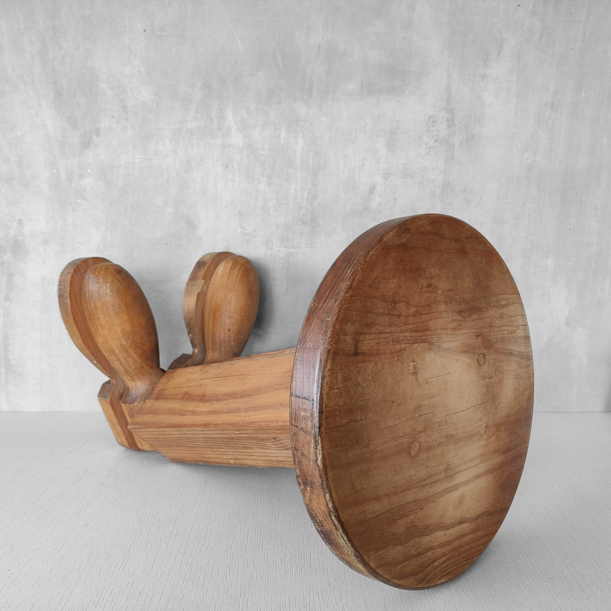 A 1980s postmodern pop art revival pine stool or plinth with booted feet