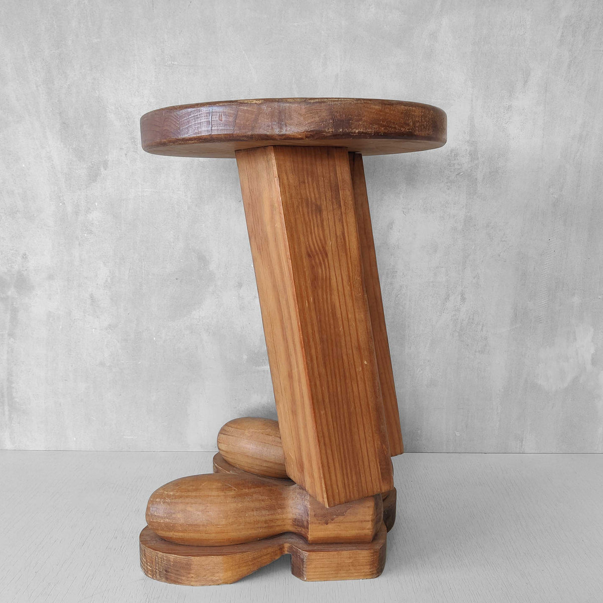 A 1980s postmodern pop art revival pine stool or plinth with booted feet