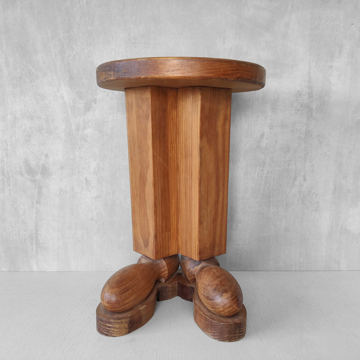 A 1980s postmodern pop art revival pine stool or plinth with booted feet