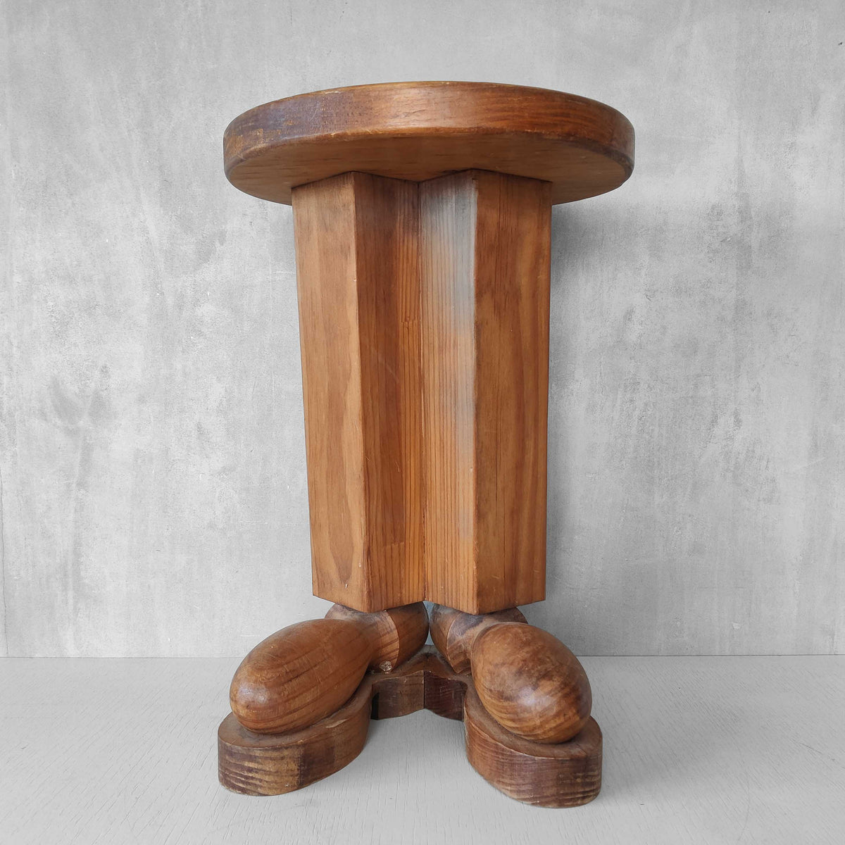 A 1980s postmodern pop art revival pine stool or plinth with booted feet