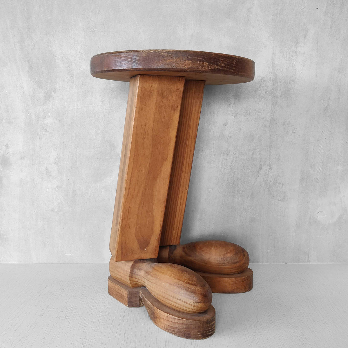 A 1980s postmodern pop art revival pine stool or plinth with booted feet