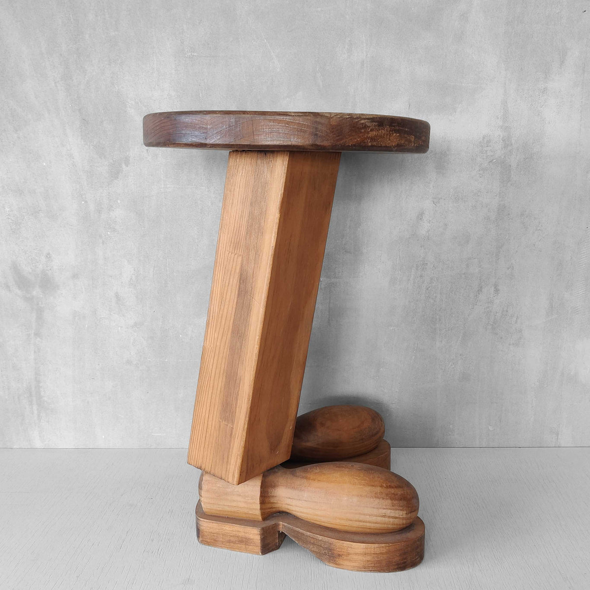 A 1980s postmodern pop art revival pine stool or plinth with booted feet