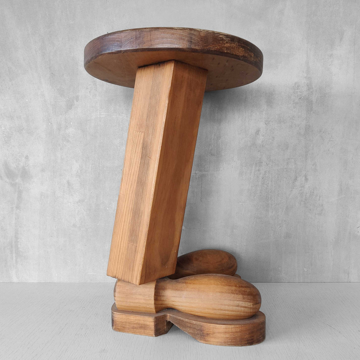 A 1980s postmodern pop art revival pine stool or plinth with booted feet