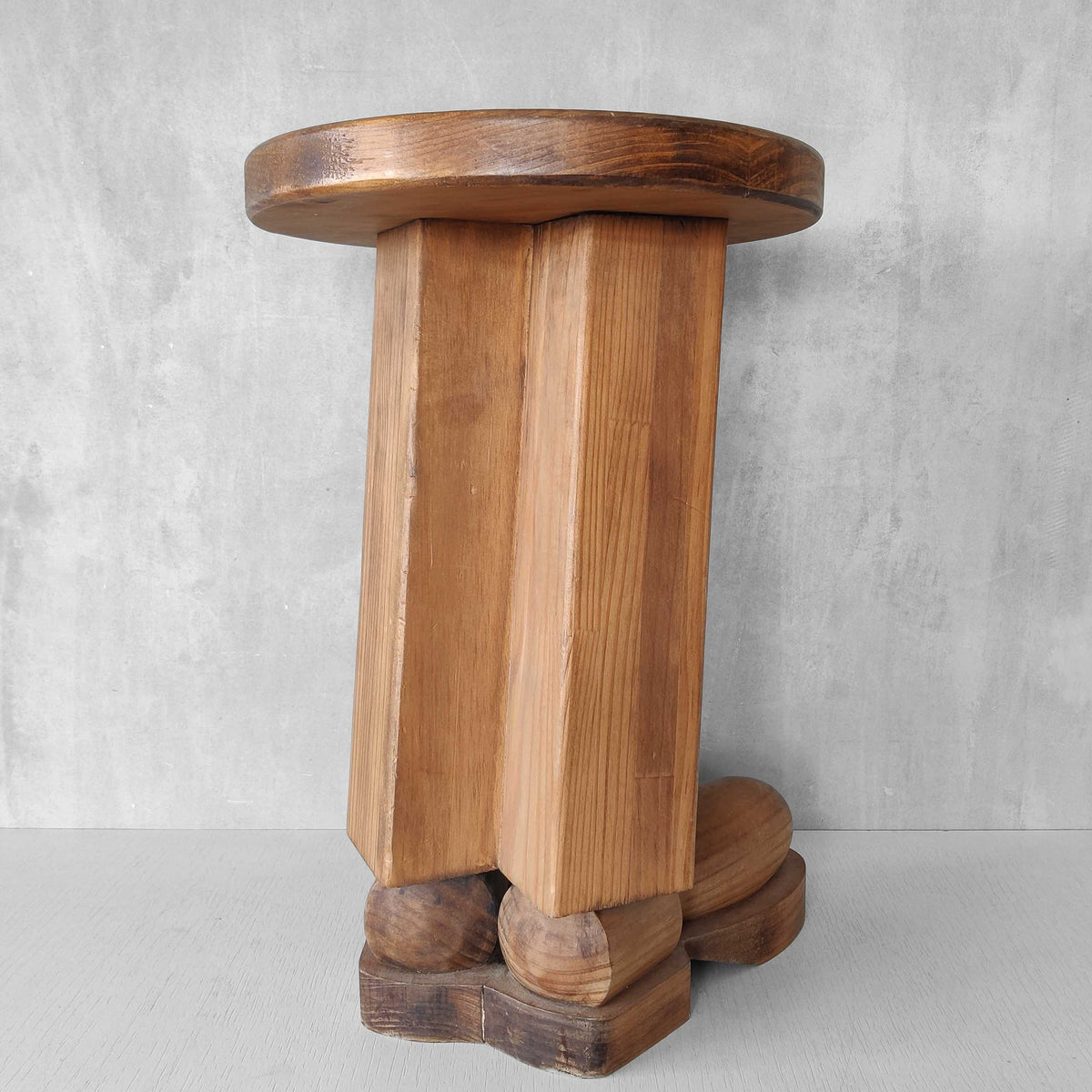 A 1980s postmodern pop art revival pine stool or plinth with booted feet