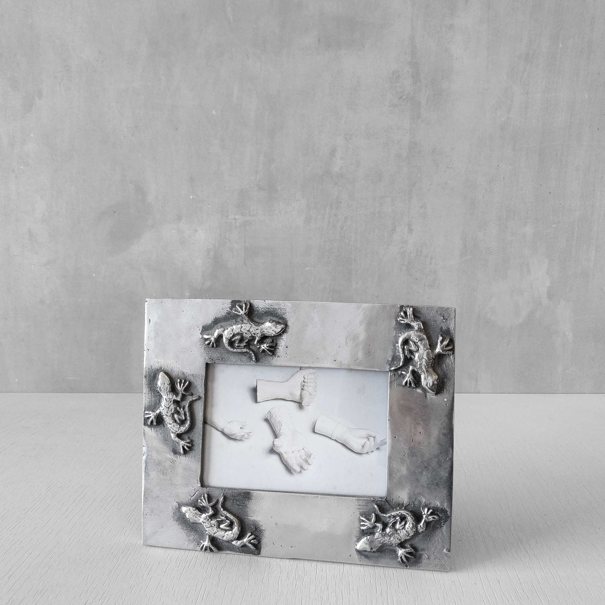 A vintage hand sand cast aluminium photo frame with gecko motifs