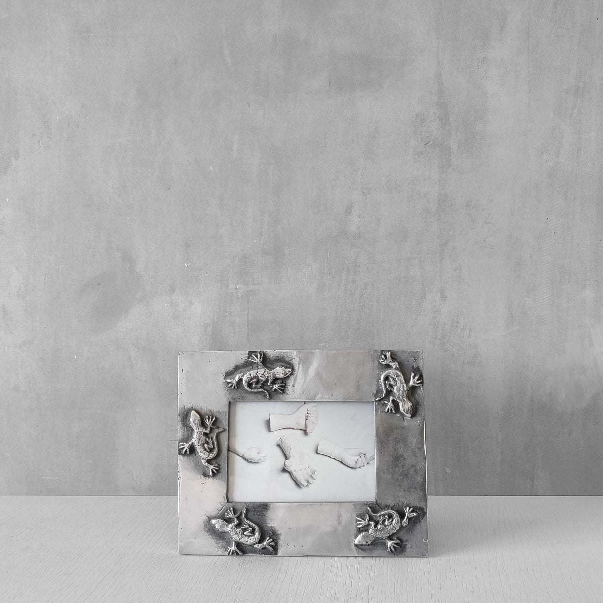 A vintage hand sand cast aluminium photo frame with gecko motifs