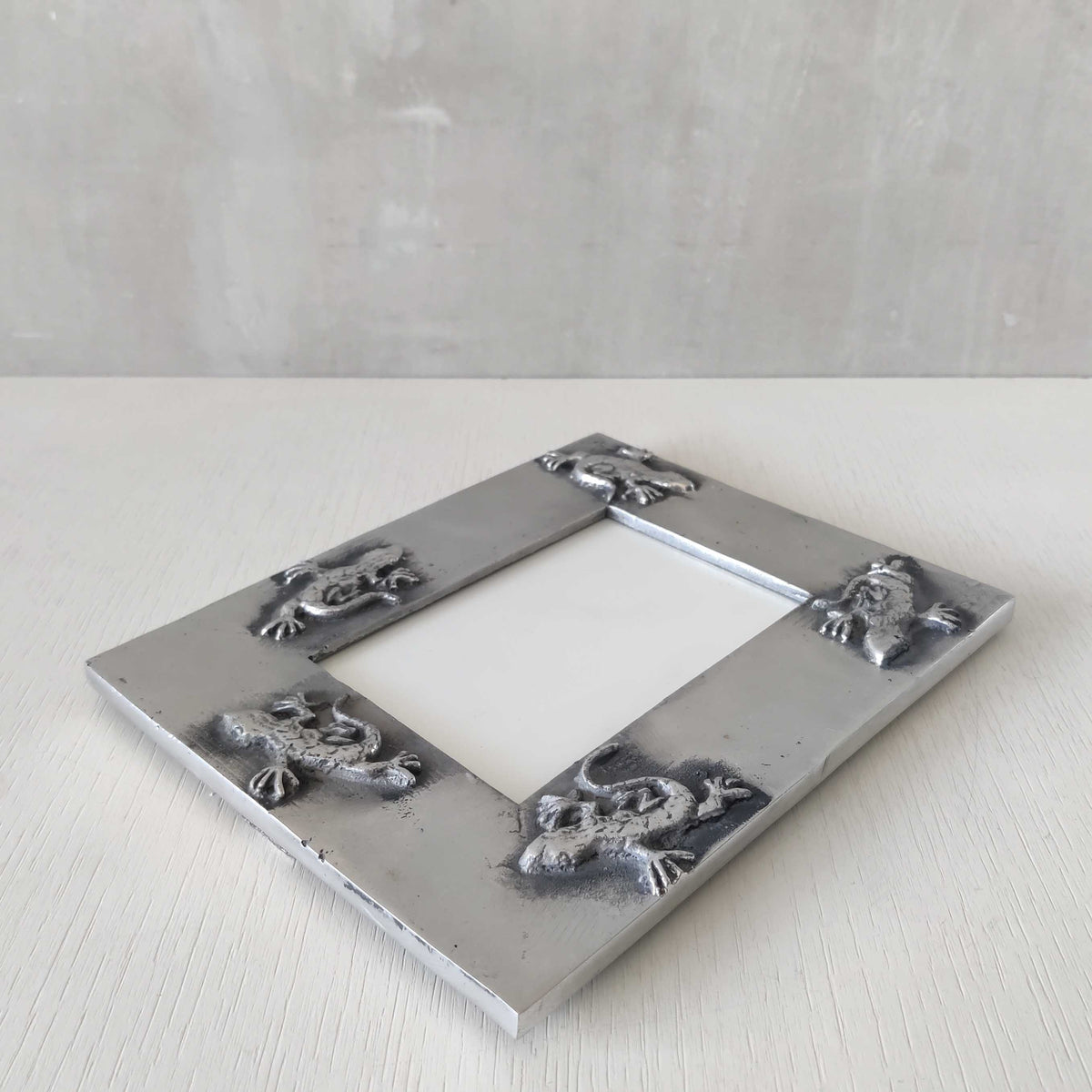A vintage hand sand cast aluminium photo frame with gecko motifs