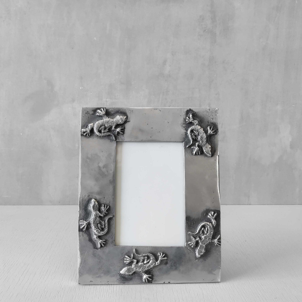 A vintage hand sand cast aluminium photo frame with gecko motifs