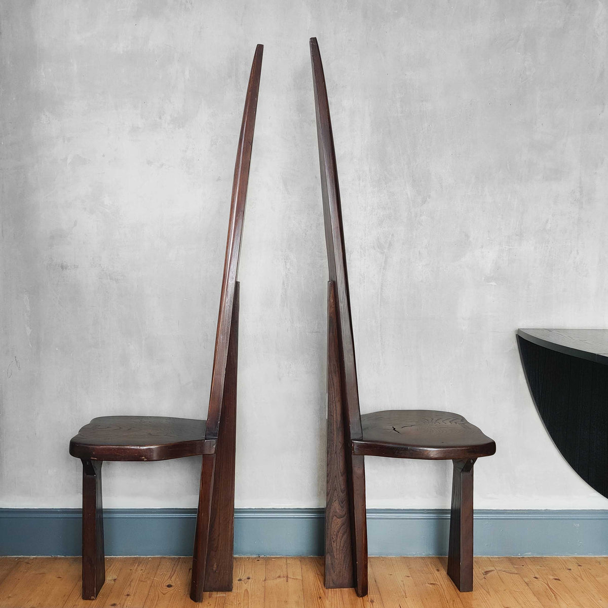 A pair of brutalist sculptural obelisk high back elm chairs