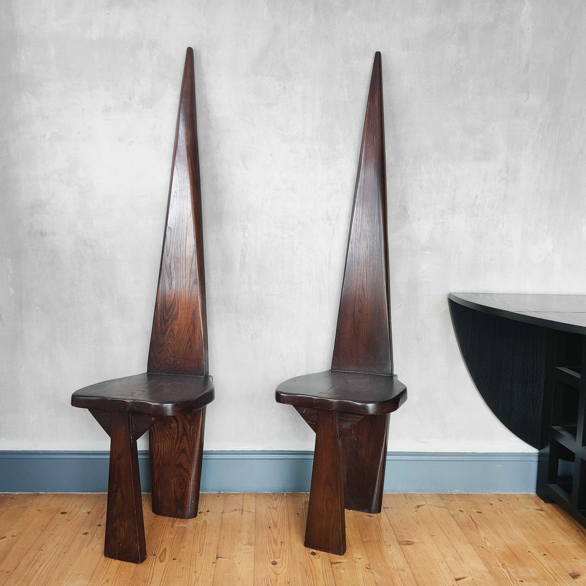 A pair of brutalist sculptural obelisk high back elm chairs