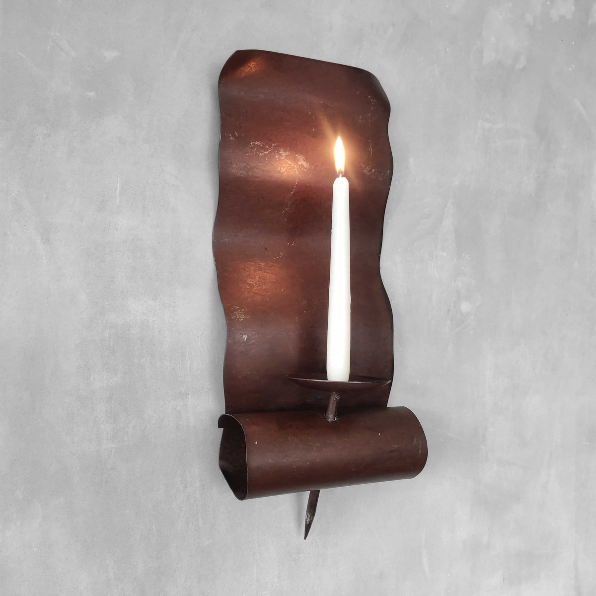 A large steel patinated wavy scrolled sculptural candle sconce