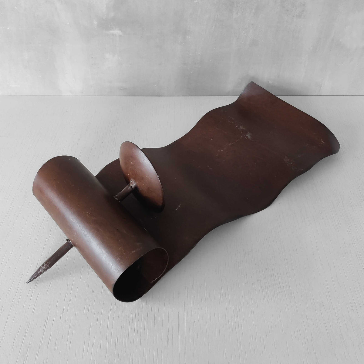 A large steel patinated wavy scrolled sculptural candle sconce