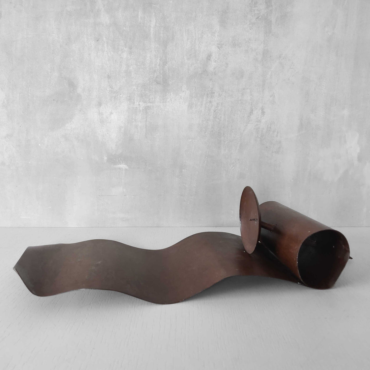 A large steel patinated wavy scrolled sculptural candle sconce
