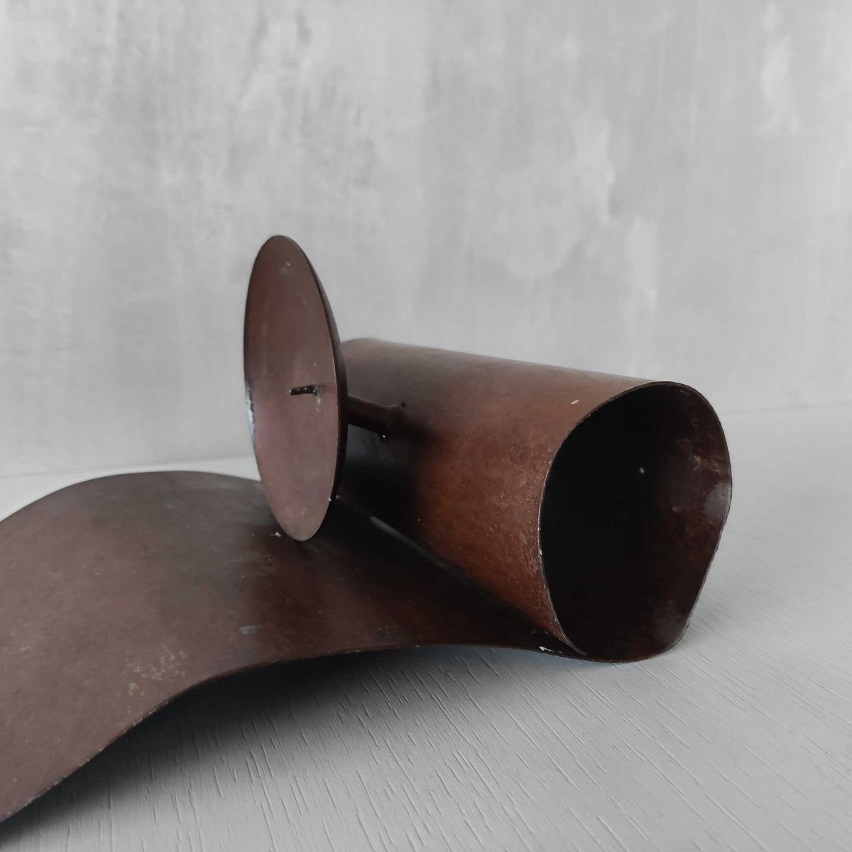 A large steel patinated wavy scrolled sculptural candle sconce