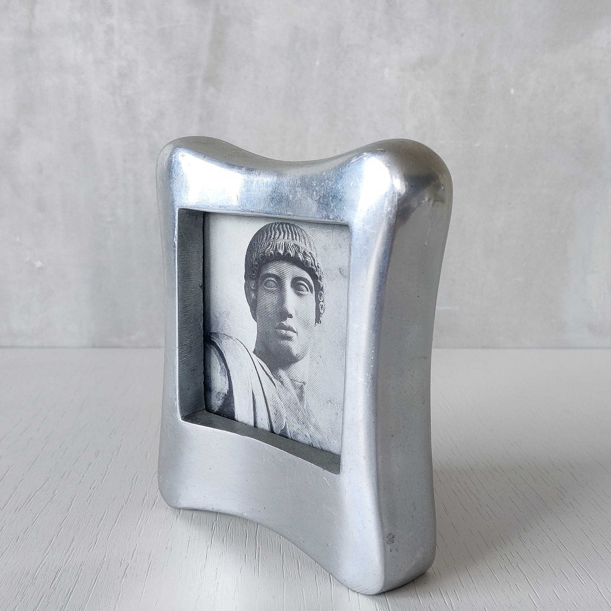A 1990s chunky cast aluminium sculptural organic form photo frame