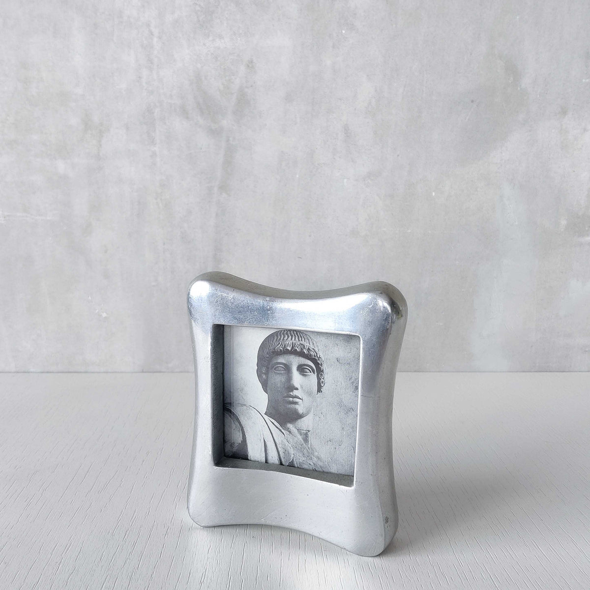 A 1990s chunky cast aluminium sculptural organic form photo frame