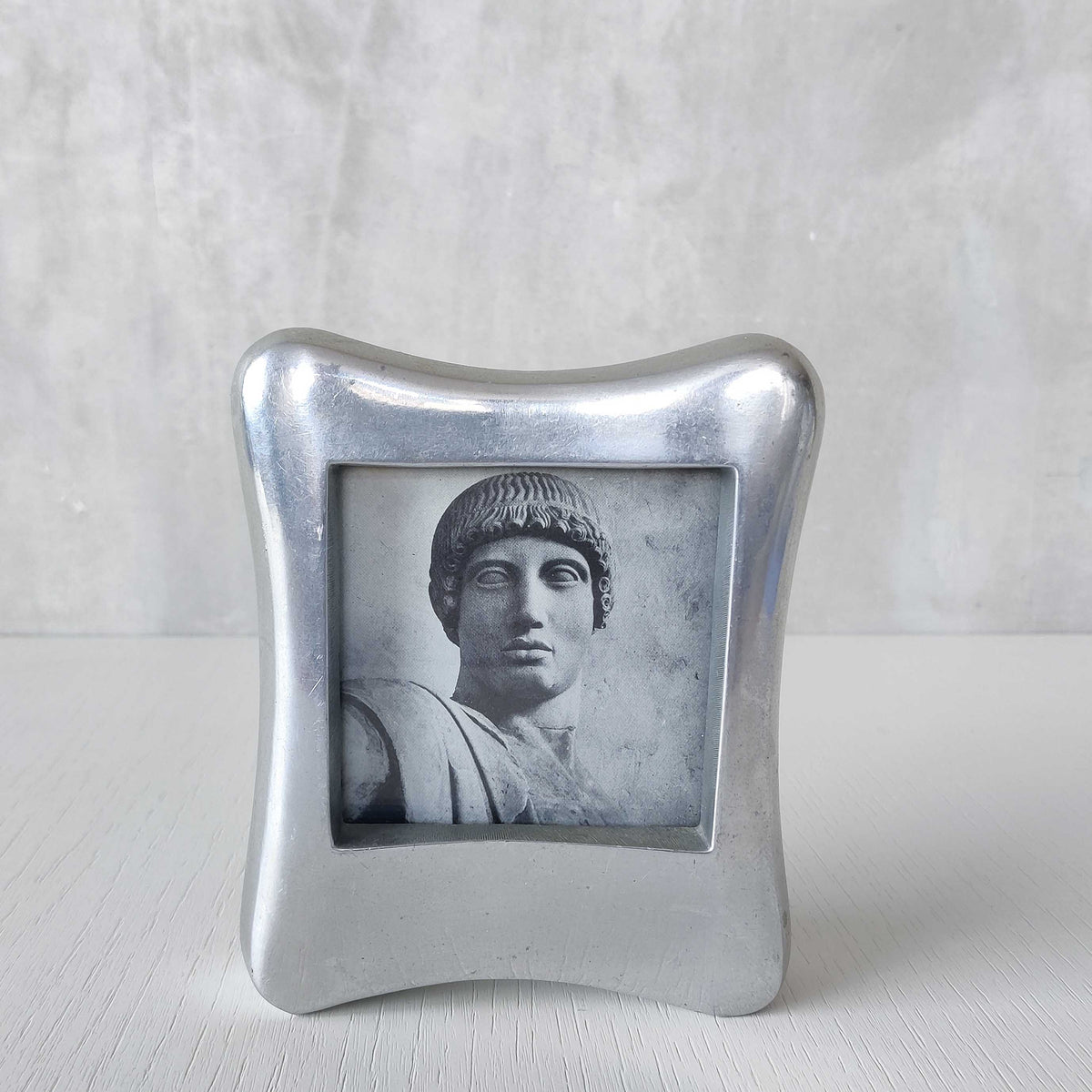 A 1990s chunky cast aluminium sculptural organic form photo frame
