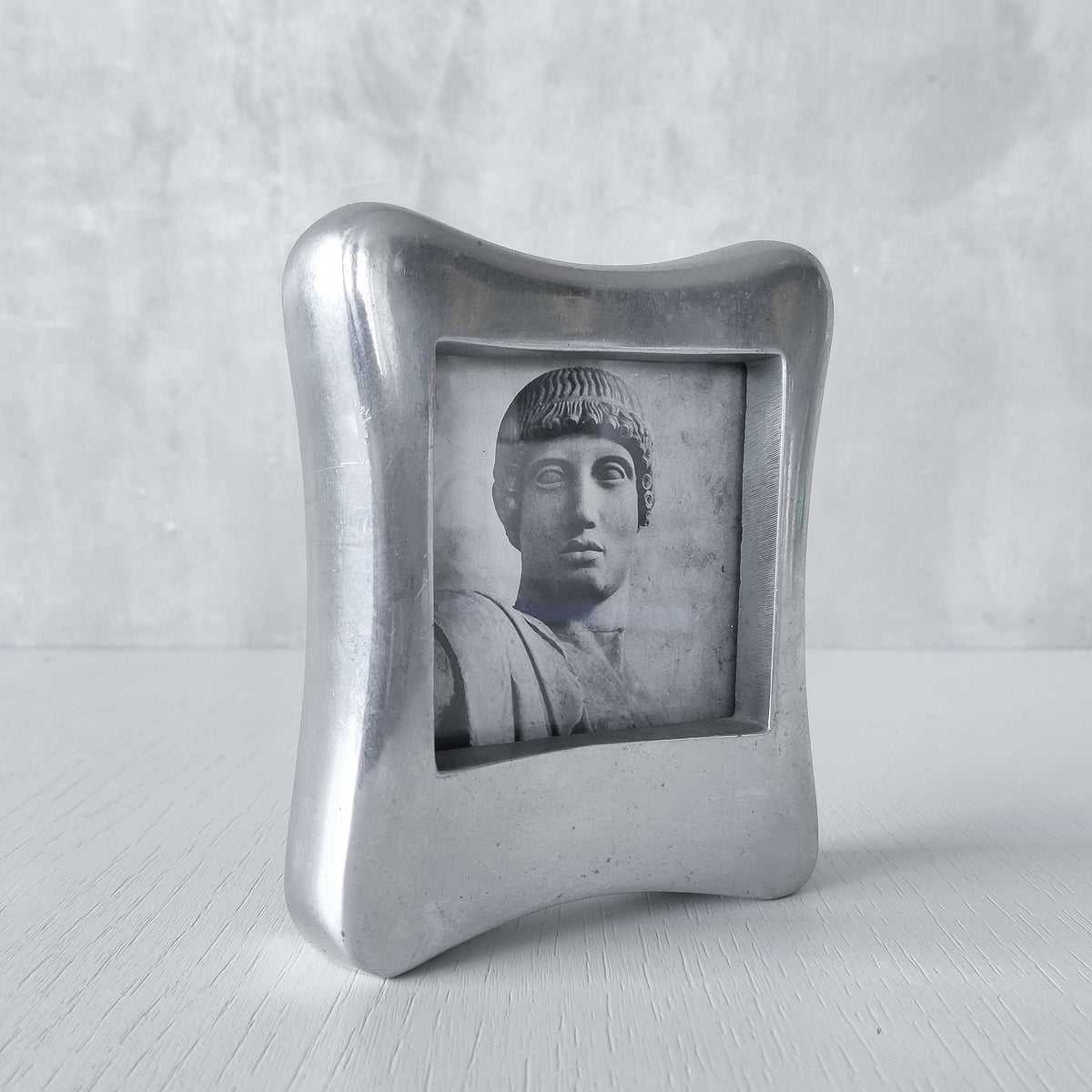 A 1990s chunky cast aluminium sculptural organic form photo frame