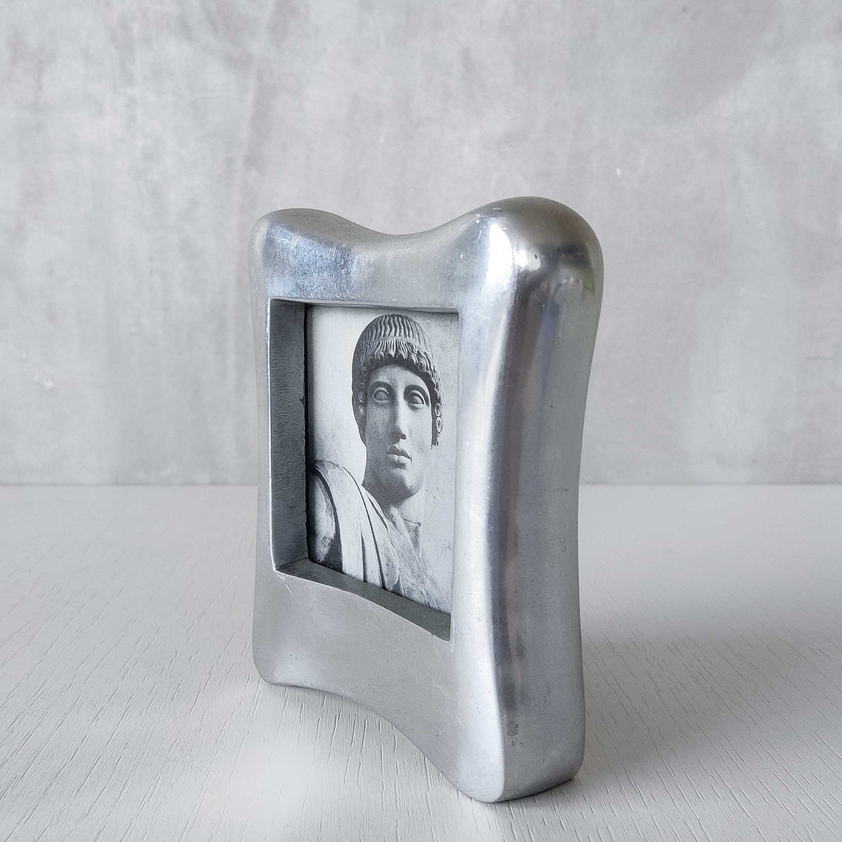A 1990s chunky cast aluminium sculptural organic form photo frame