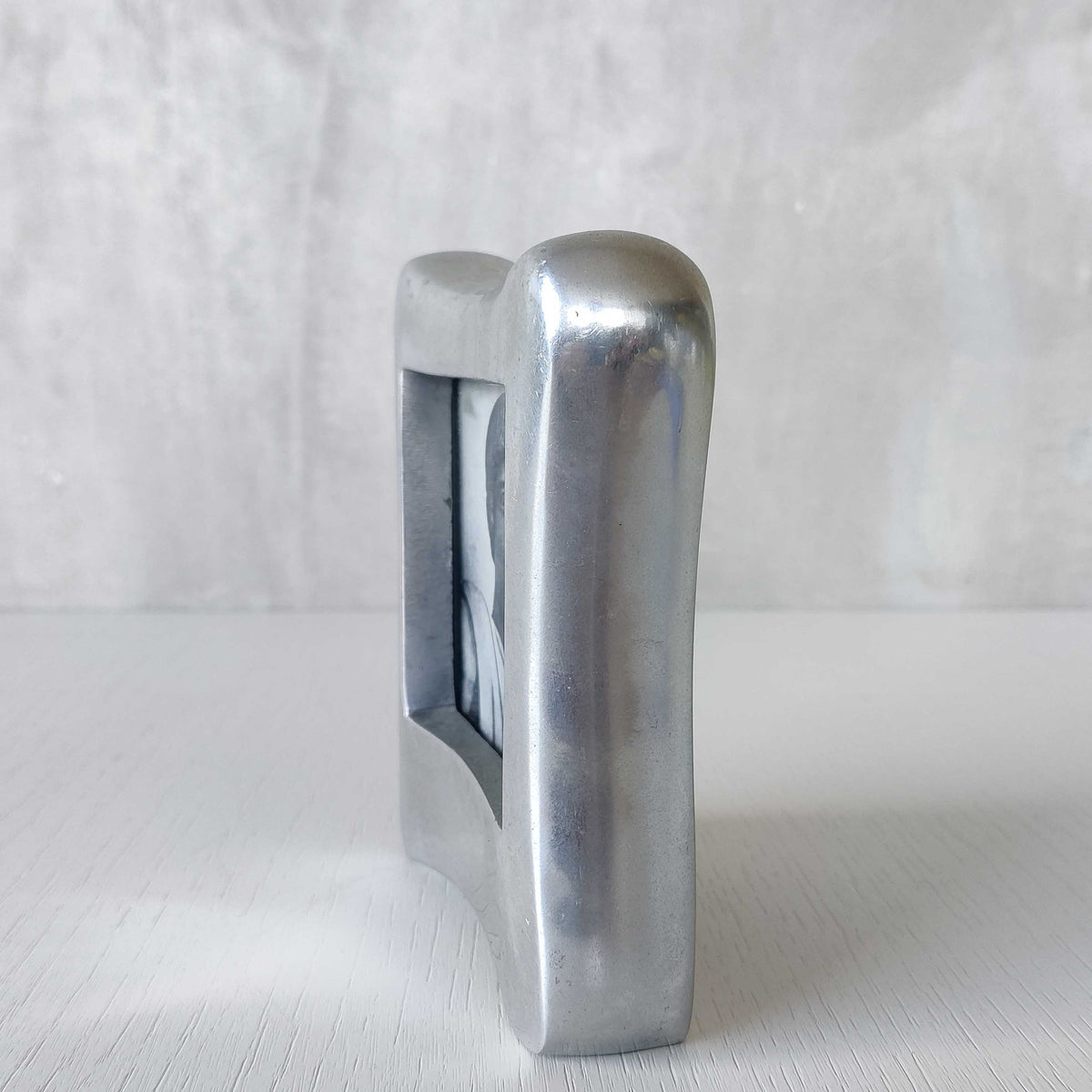 A 1990s chunky cast aluminium sculptural organic form photo frame