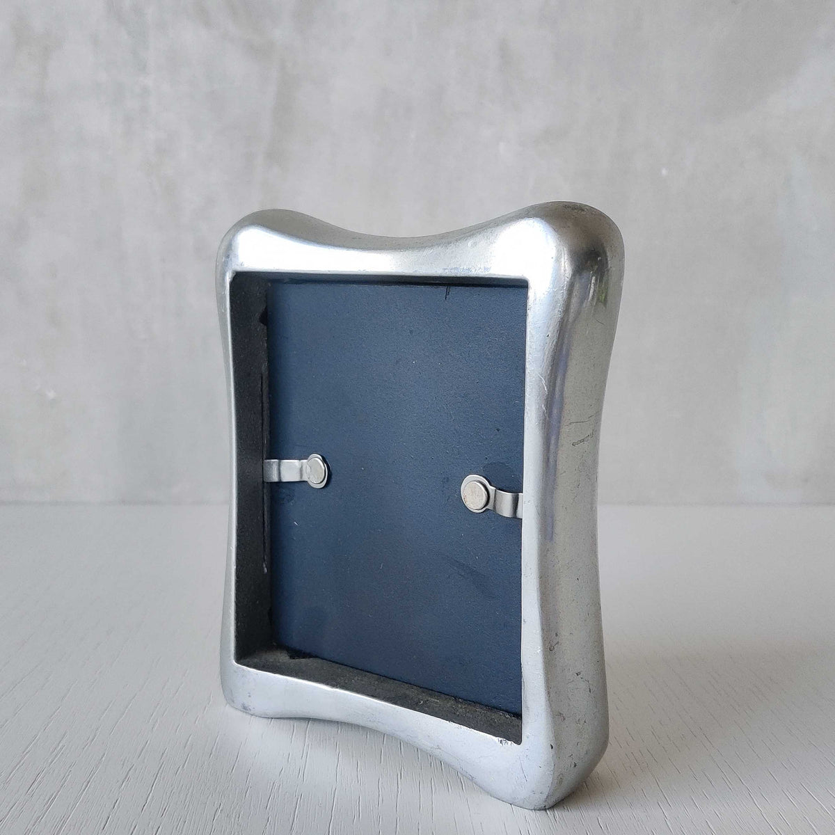 A 1990s chunky cast aluminium sculptural organic form photo frame