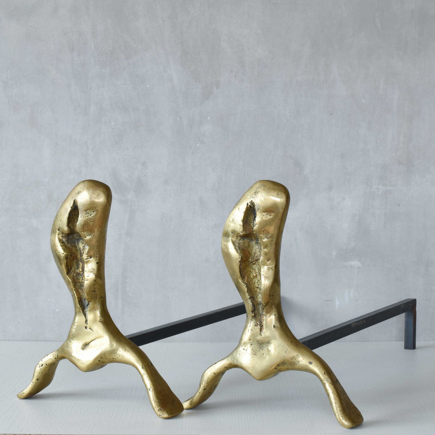 A David Marshall pair of organic brutalist sand cast brass sculptural fire dogs