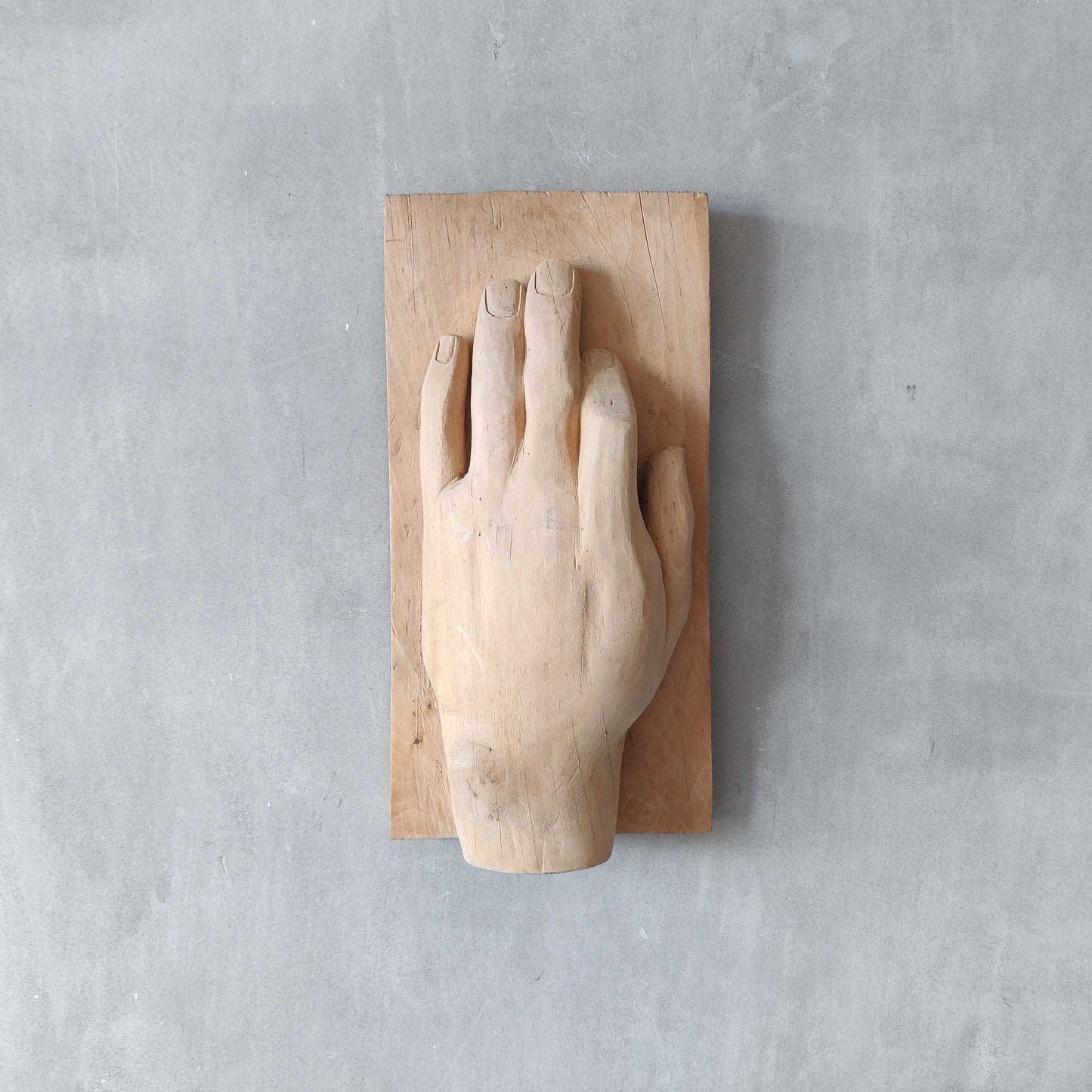 A carved tulip wood hand wall relief sculpture