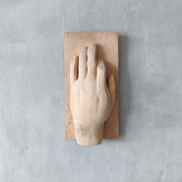 A carved tulip wood hand wall relief sculpture