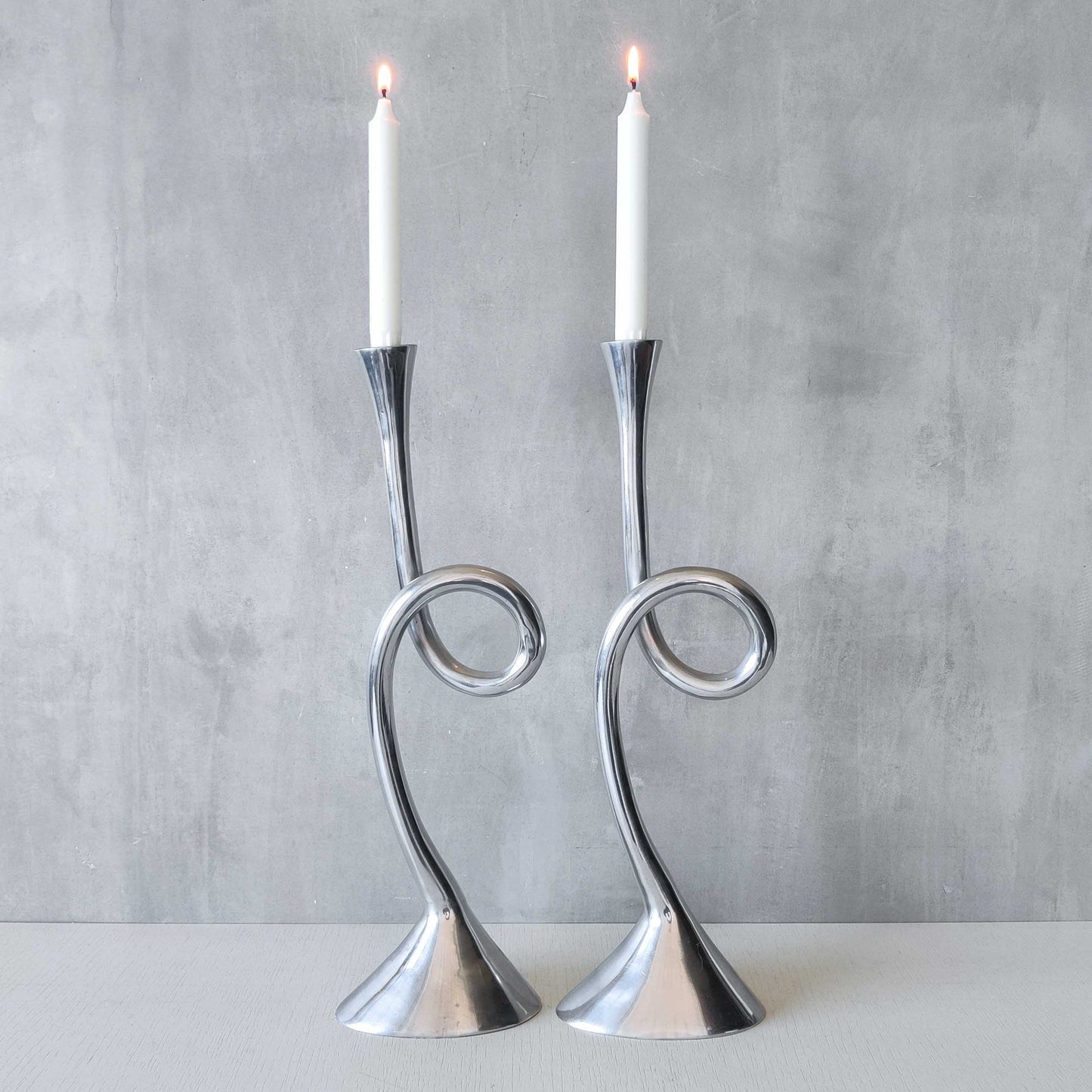 A pair of large vintage cast aluminium knotted loop candle holders