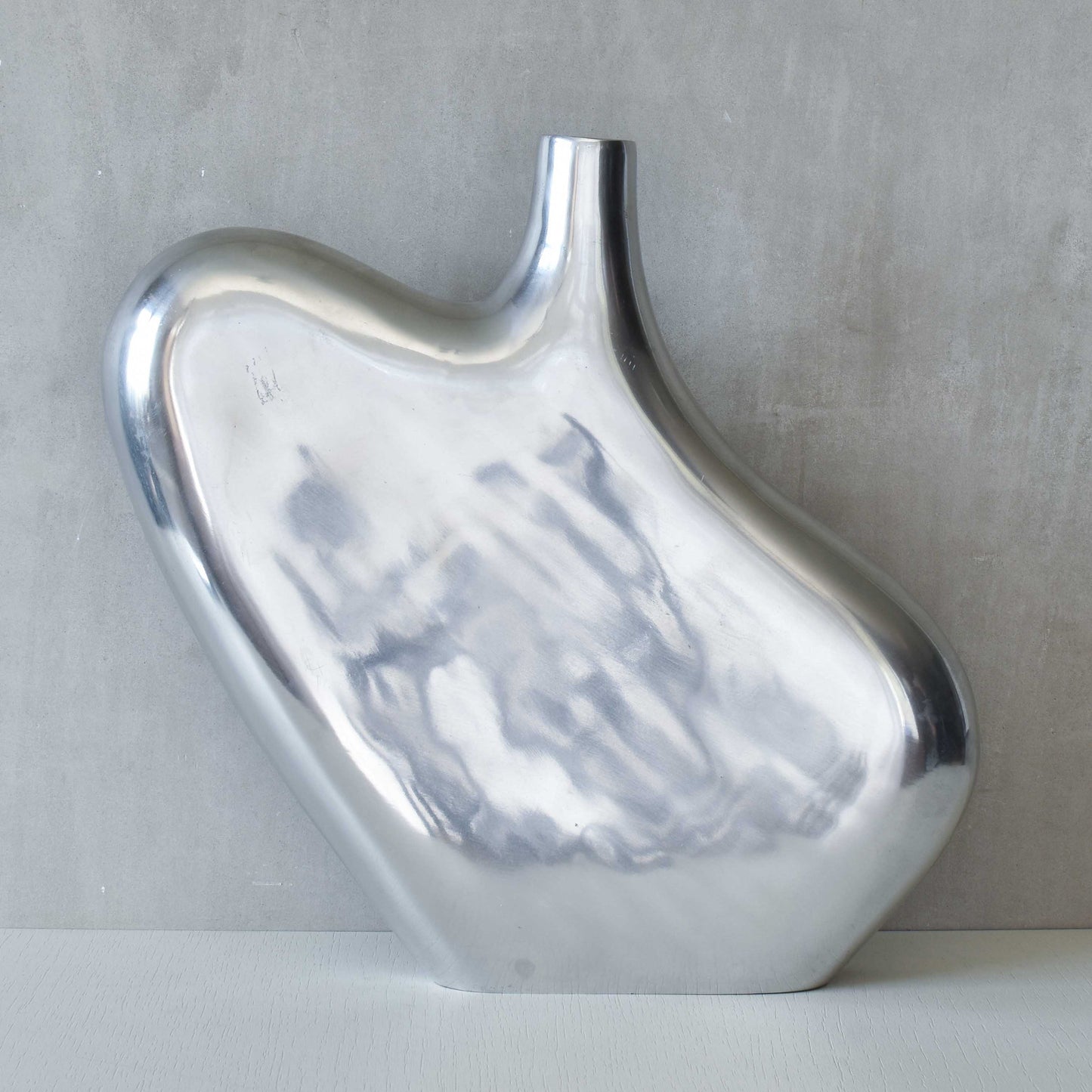 A large cast aluminium sculptural asymmetric vase