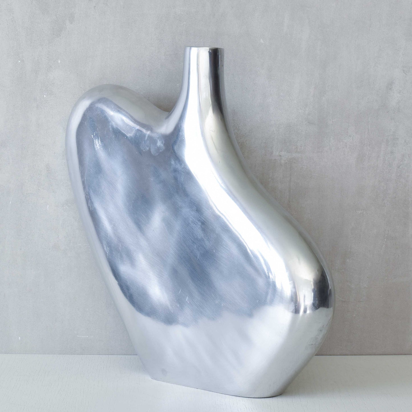 A large cast aluminium sculptural asymmetric vase