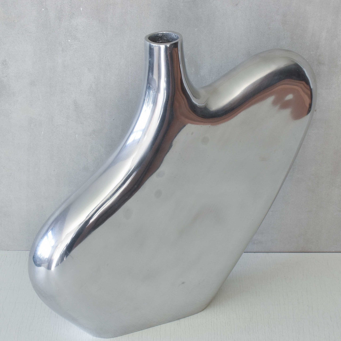 A large cast aluminium sculptural asymmetric vase