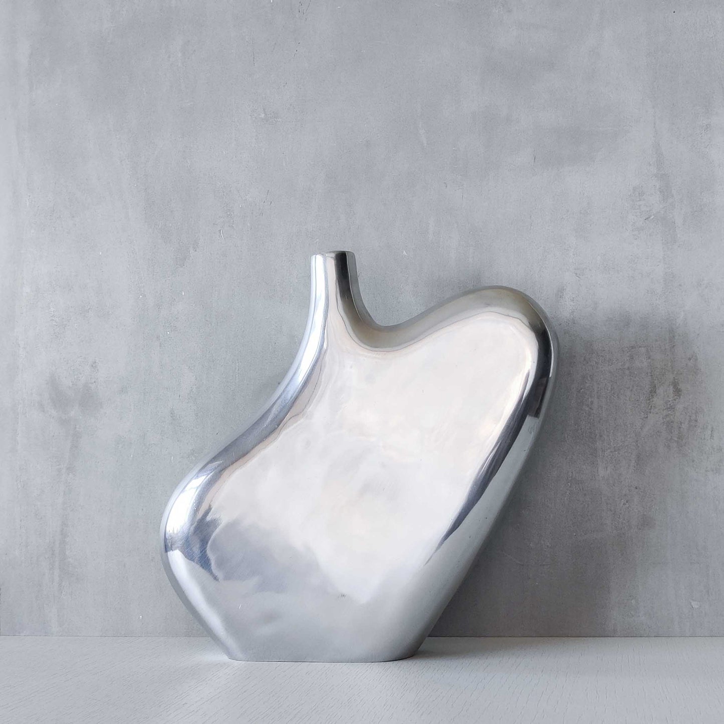 A large cast aluminium sculptural asymmetric vase
