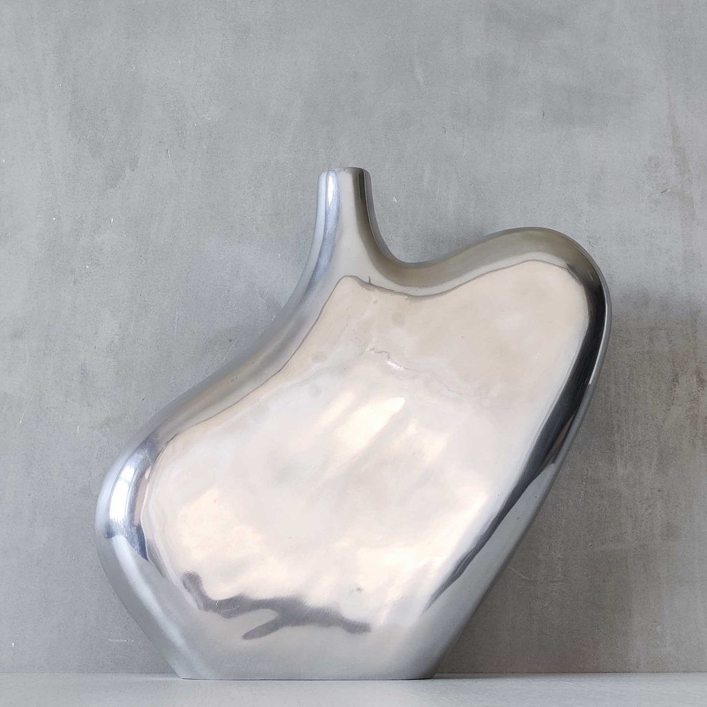 A large cast aluminium sculptural asymmetric vase