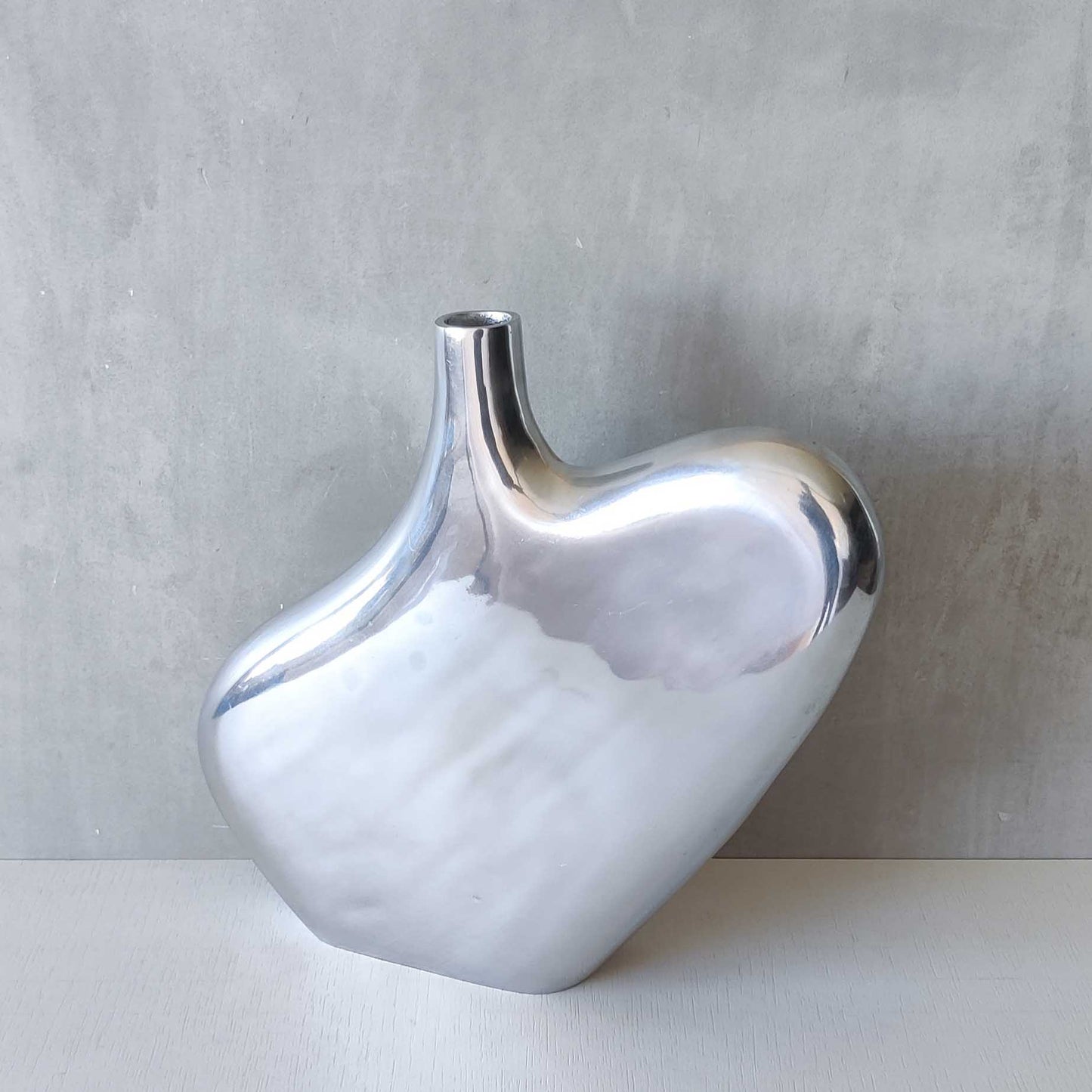 A large cast aluminium sculptural asymmetric vase