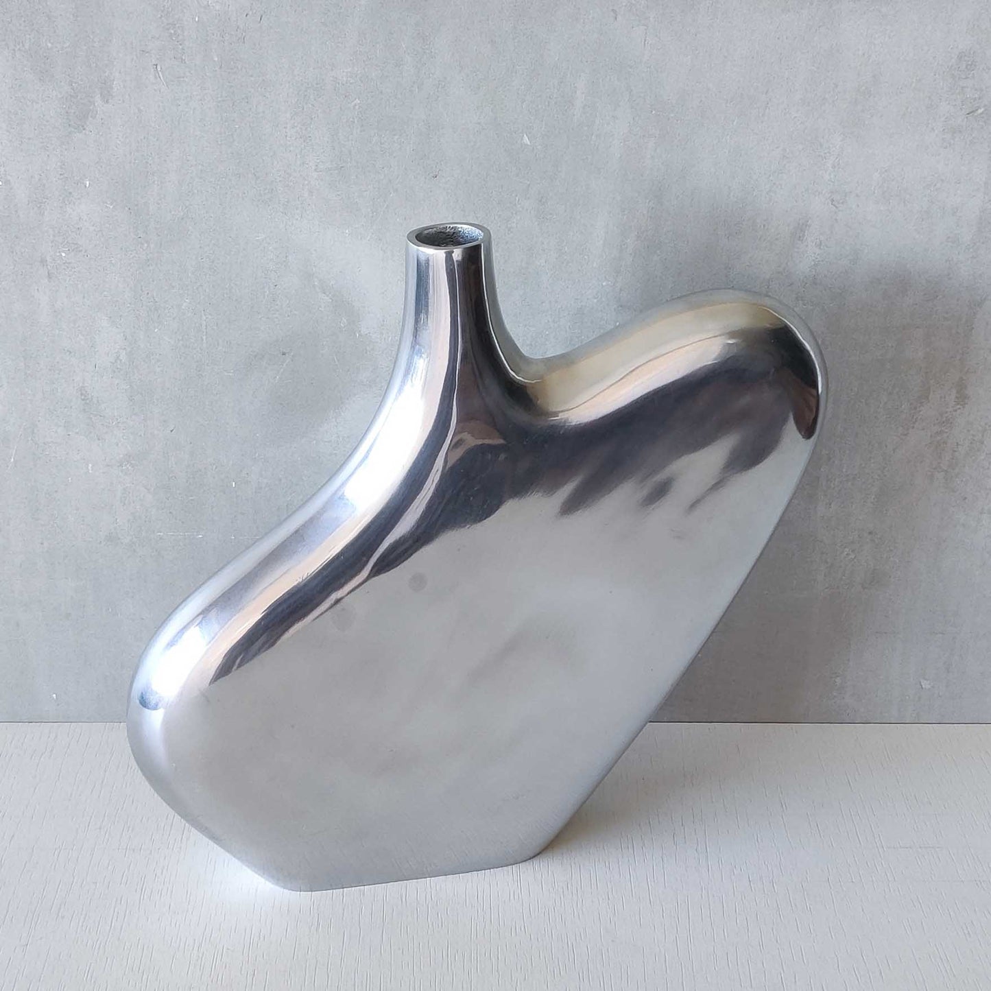 A large cast aluminium sculptural asymmetric vase